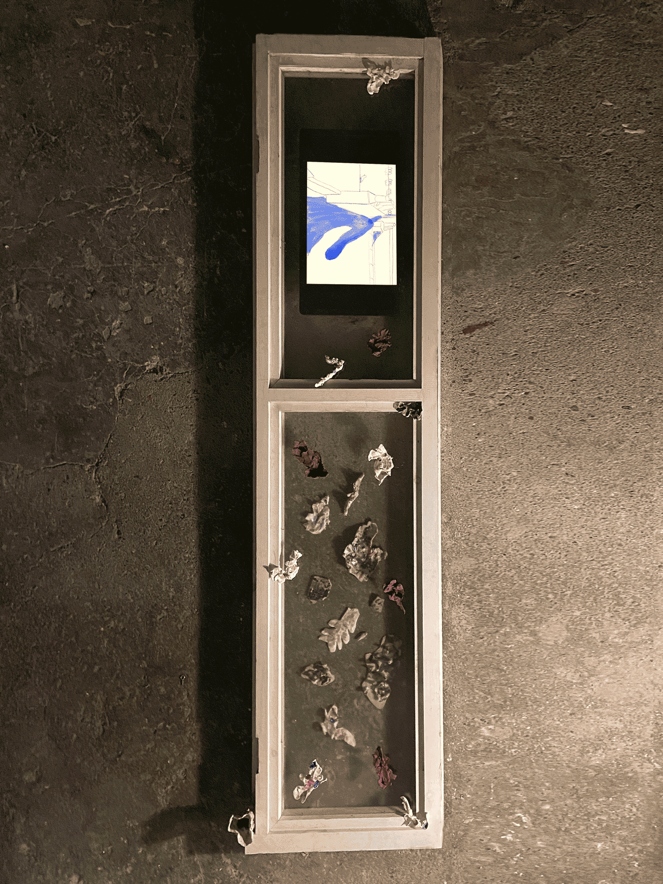 Gif of art work in a small display case screen displaying small objects.